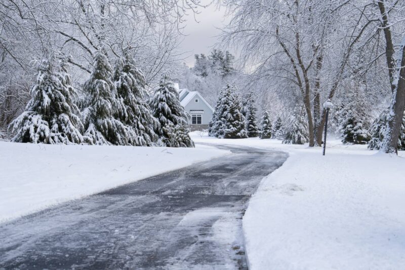 Snow shovel leaning against a cleared walkway